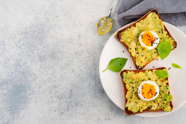 istock Healthy avocado toasts with eggs on table 2190726597