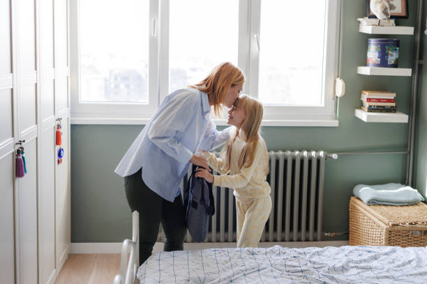 istock Parenting and career: A mother kissing her daughter before going to work 2190726679