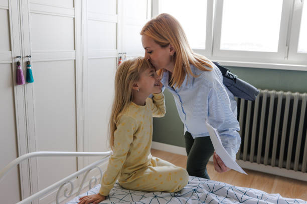 istock Daughter sitting on the bed as mom prepares to leave 2190726749