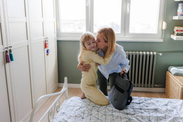 istock A working mother kissing her cute daughter before going to work 2190726778
