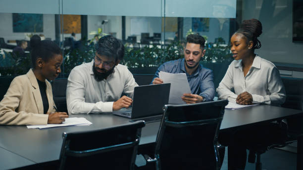 istock Creative diverse multiracial professional multiethnic business team partners workers colleagues working together discussing project ideas with laptop and documents at office meeting brainstorming 2190726809