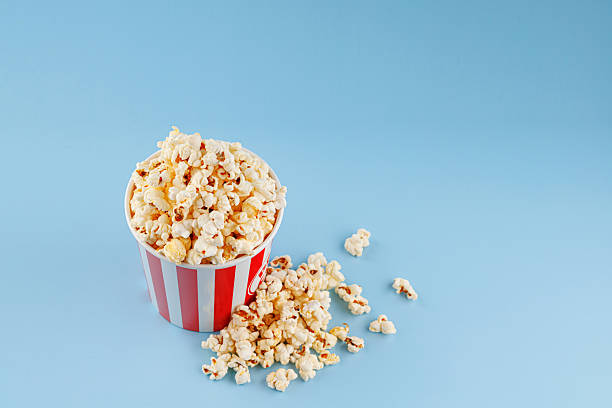 istock Classic red striped popcorn cardboard cup on blue background 2190727051