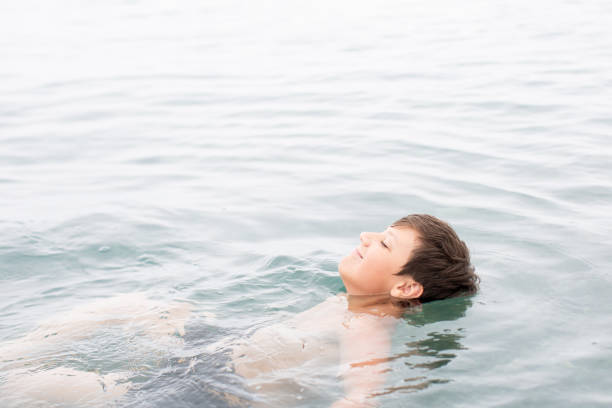 istock Carefree boy floating in the ocean 2190727342