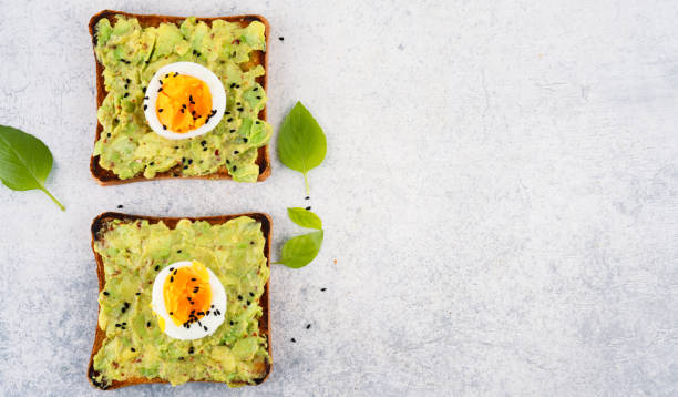 istock Healthy avocado toasts with eggs on table 2190727534