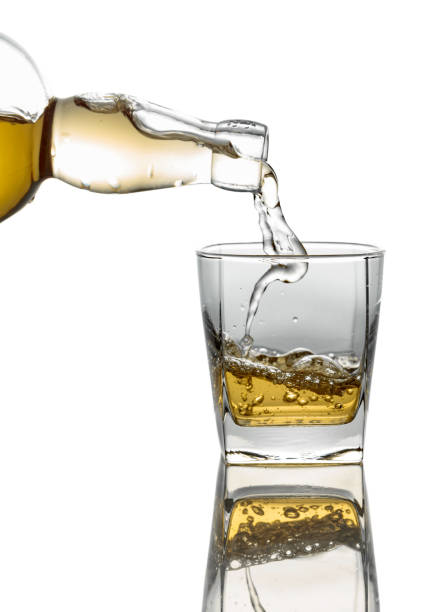 istock Pouring whiskey from a bottle into a glass on a white background. 2190728891