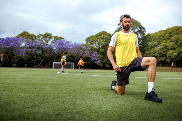 istock Soccer player doing warming up exercise on a soccer field during training session 2190730292