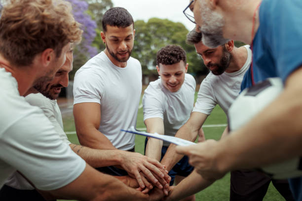 istock Soccer players stacking arms with their coach before game 2190730357
