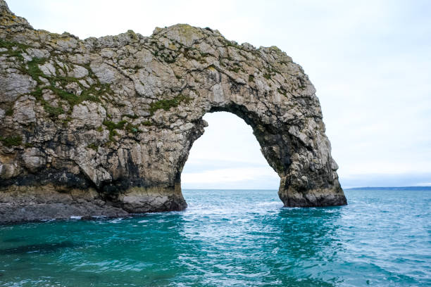 Durdle Door limestone arch on the Jurassic Coast in Dorset. Natural landmark. England. Pure clean clear water. Winter cold day at Durdle Door in Dorset, England, UK