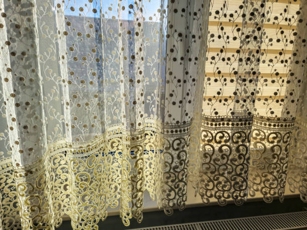 istock Beautiful lace curtains illuminated by sunlight, creating a soothing atmosphere in a home. Perfect for interior decoration or window treatment ideas. 2190732730