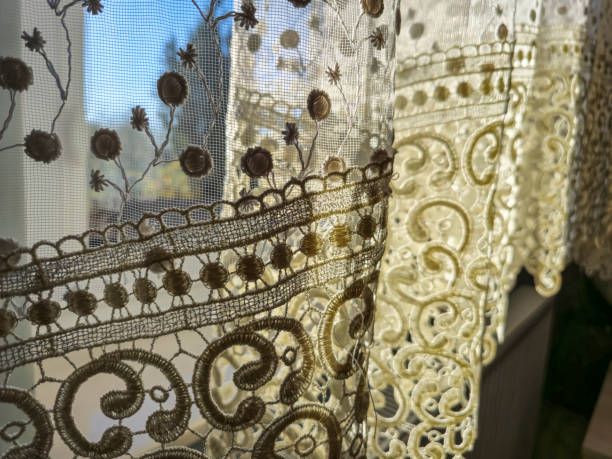 istock Delicate lace curtains gently illuminated by sunlight, creating a warm and inviting atmosphere in a cozy home. 2190733791