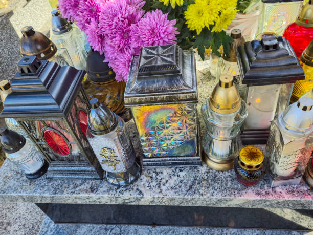 A collection of decorative lanterns on a gravestone, surrounded by vibrant flowers, symbolizing remembrance and honoring loved ones. Perfect for themes of memory and reflection.