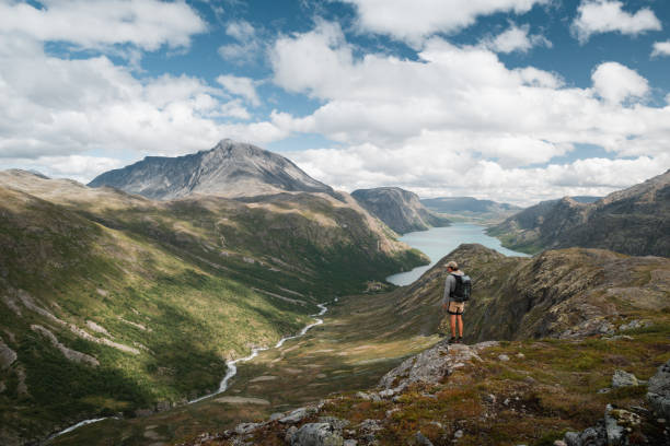 istock Trekker admiring Norway's Jotunheimen mountains and winding river. 2190734299