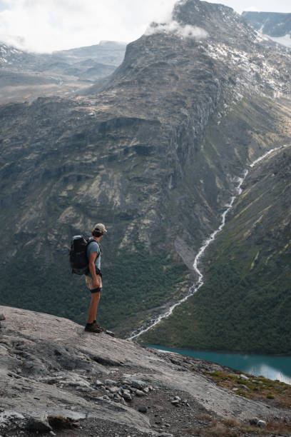 istock Trekker Standing Before Majestic Norwegian Mountain with Dramatic Waterfall 2190734303