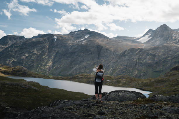 istock Female trekker exploring Norway's rugged mountain landscape and tranquil lake. 2190734349