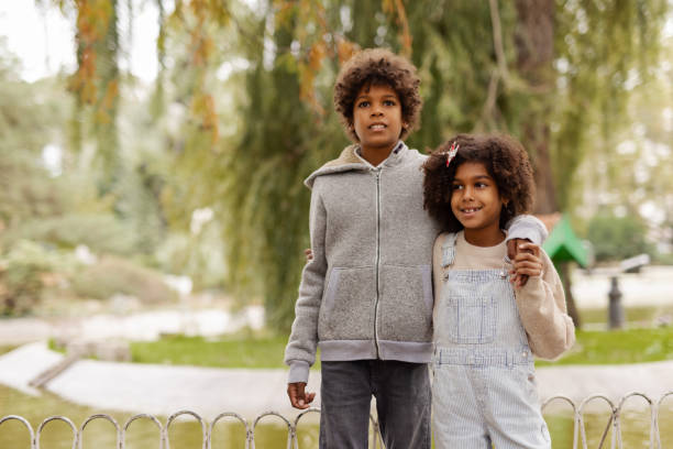 istock Loving Black Siblings Embrace While Strolling Through a Scenic Park 2190734958