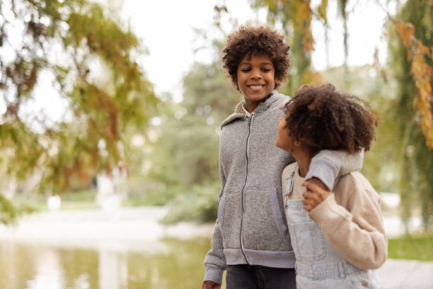 istock Loving Black Siblings Embrace While Strolling Through a Scenic Park 2190735047