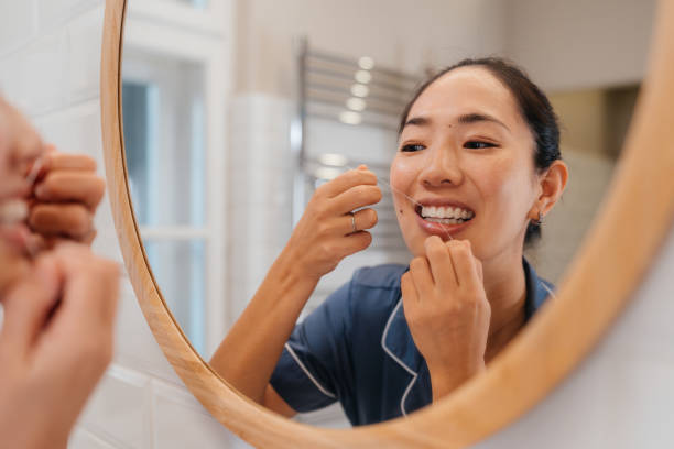istock Woman using dental floss as part of her oral hygiene routine 2190736735