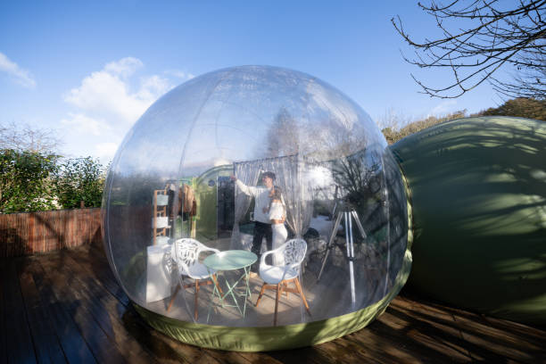 istock Romantic couple capturing selfie inside transparent bubble hotel, nestled within lush natural landscape, sharing intimate travel moment 2190738271