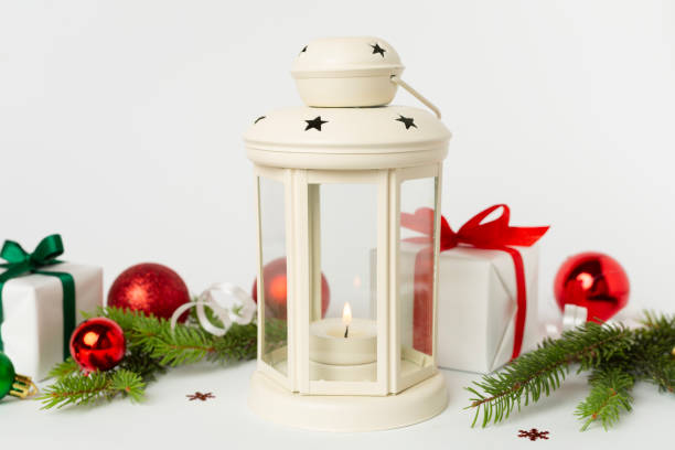 Beige christmas lantern with decorations on color background
