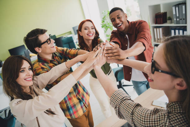 istock Photo of pretty young colleagues highfive teamwork training startup project team coworking successful nice light office 2190739907