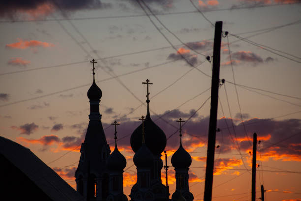 village church in silhouette against sunset, domes and lamp posts. High quality photo