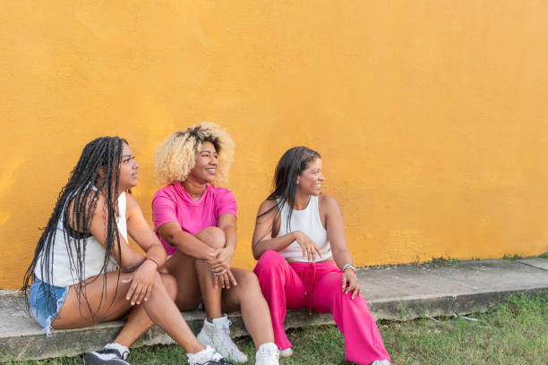 istock Three women relaxing and chatting by yellow wall 2190747388