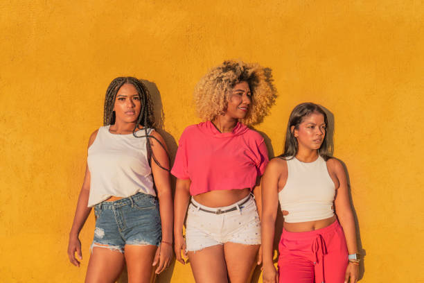 istock Three young women posing against a vibrant yellow wall 2190747539