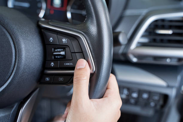 istock Woman's hand presses the button on the steering wheel of the car close-up. Multi function buttons 2190753086