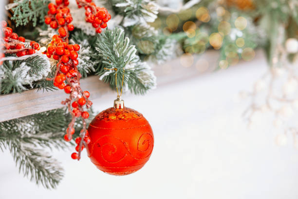 istock Bright red ornament hanging from snowy Christmas tree branches 2190758164