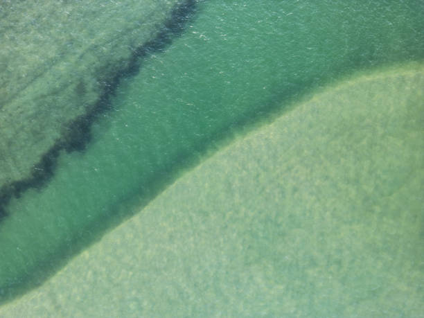 Abstract top down view of coastal sand bar and shallow water