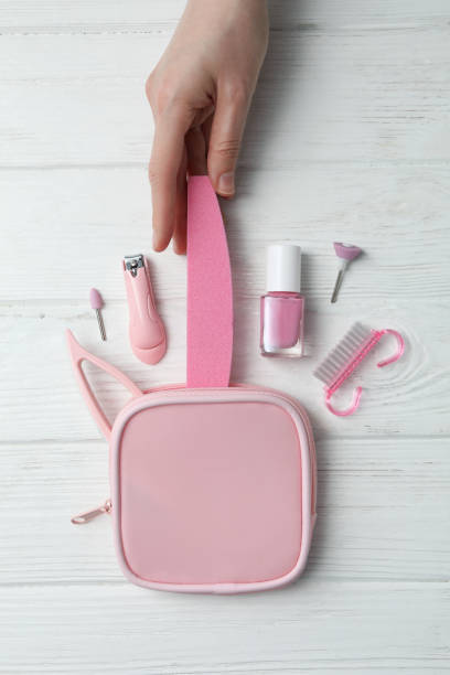 istock Manicure tools, case and female hand on light wooden background, top view 2190768274