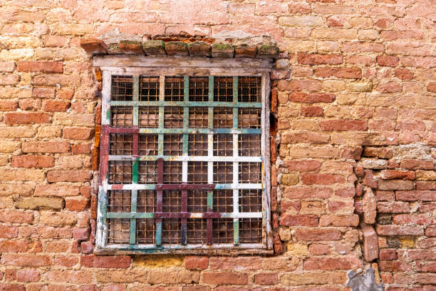 Italy, Venice. Castello district. Old brick wall and barred window.