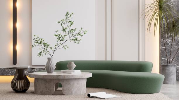 istock A modern living room with a curved green sofa, a round concrete coffee table, and minimalistic decor featuring a vase and a small plant. 3D rendering 2190777113