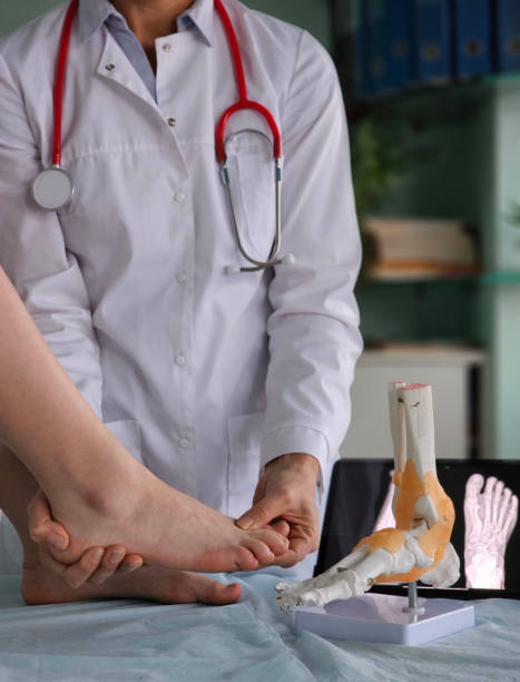 istock Medical professional examining a patient foot with anatomical model 2190778470