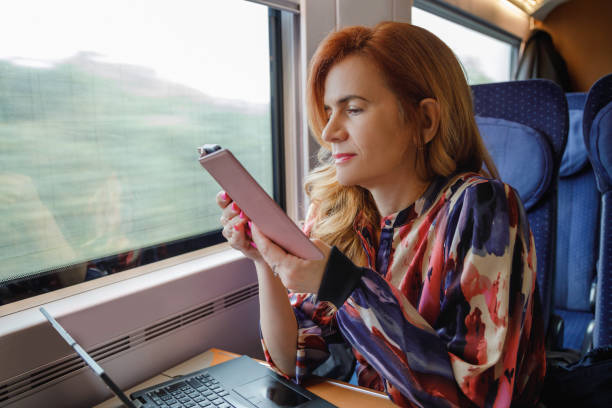 istock Beautiful woman riding train by day and using her smart phone 2190780208