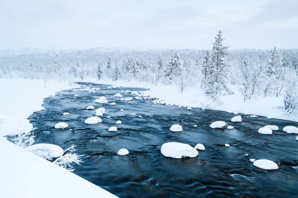 istock Winter river landscape with snow-covered banks and rocks in a serene environment 2190781111