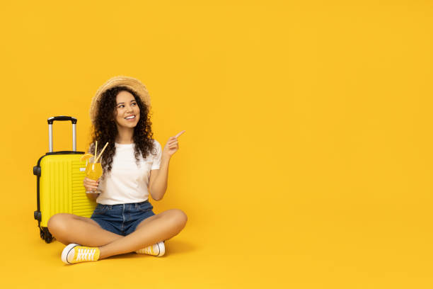 istock Young woman with suitcase on yellow background 2190784171