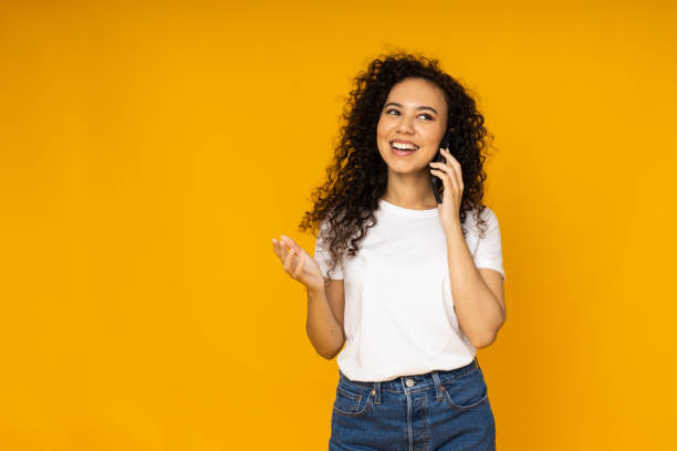 istock Young woman with phone on yellow background 2190784211