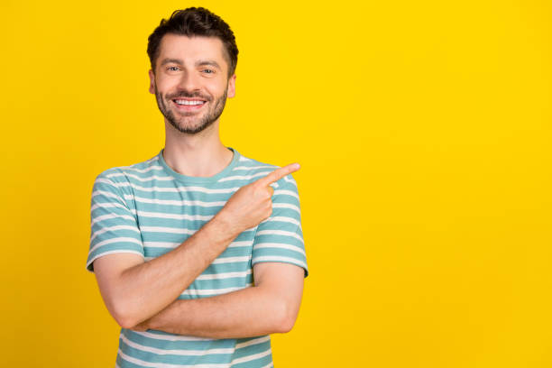 istock Portrait of young attractive smiling beaming guy pointing empty space good dentistry clinic isolated on yellow color background 2190789241