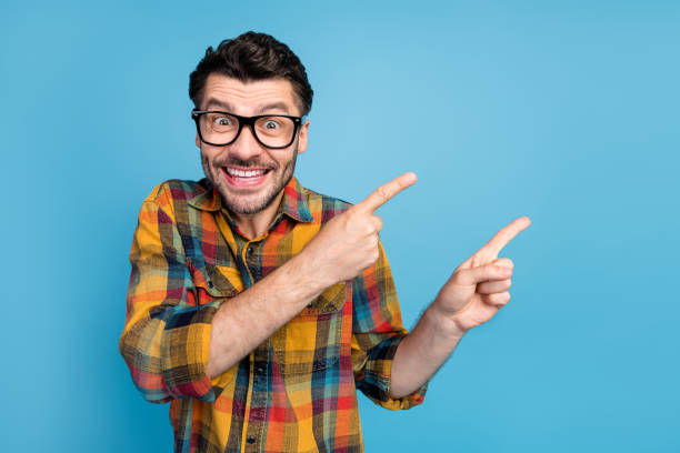 istock Photo of speechless staring handsome guy in glasses dressed checkered shirt indicating empty space isolated on blue color background 2190789762