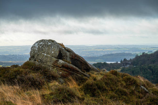 A bleak atmospheric rural winter landscape with a dark dramatic moody sky in the Peak District, England, UK.