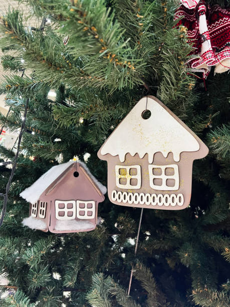 istock Decorative house ornaments hanging on a lush green Christmas tree 2190794897