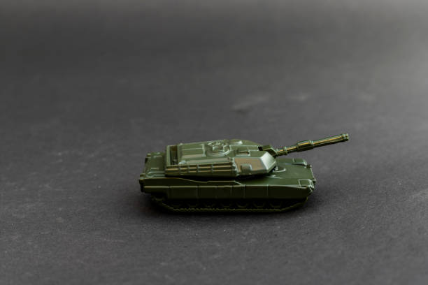 istock Green toy tank model side view on black background 2190796950