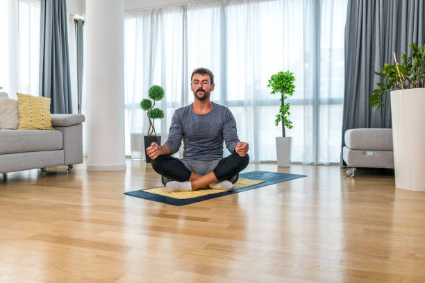 istock Home workout. Young healthy happy self aware confident man practicing sport training at home in his apartment, stretching muscles and breeding exercise for better life and success. 2190797320
