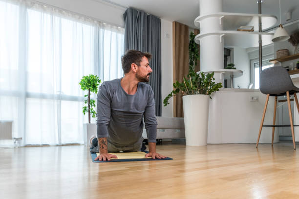 istock Home workout. Young healthy happy self aware confident man practicing sport training at home in his apartment, stretching muscles and breeding exercise for better life and success. 2190797330