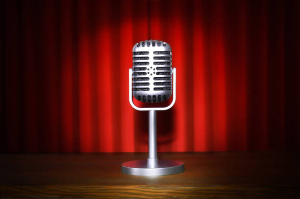 istock Vintage microphone on stage in the center with red curtains 2190797551