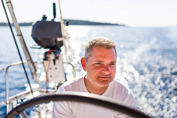 Skipper sailing on sailboat on autopilot.