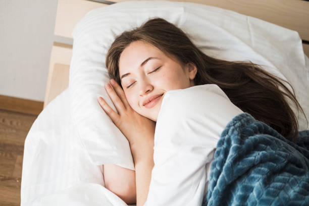 istock A beautiful young Caucasian brunette woman is sleeping on a bed. 2190803398