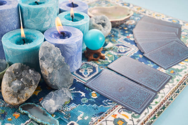 istock Mystical Card Reading Setup. Blue candles, crystals, and tarot cards on a patterned cloth. 2190805038