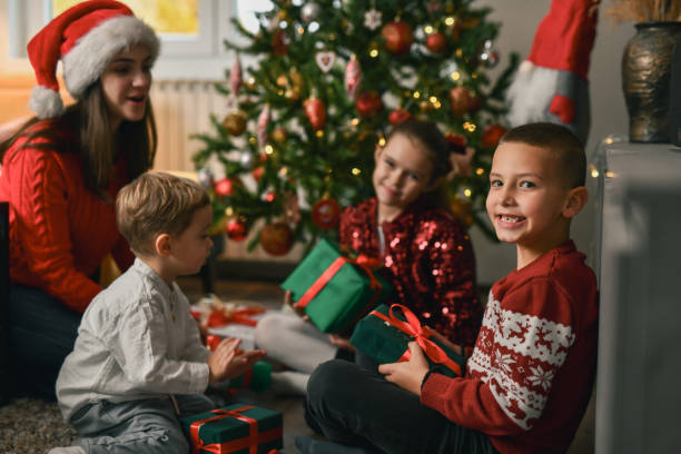 istock Smiling Boy Waiting in Anticipation to Open Gift He Received From Older Sister 2190805521